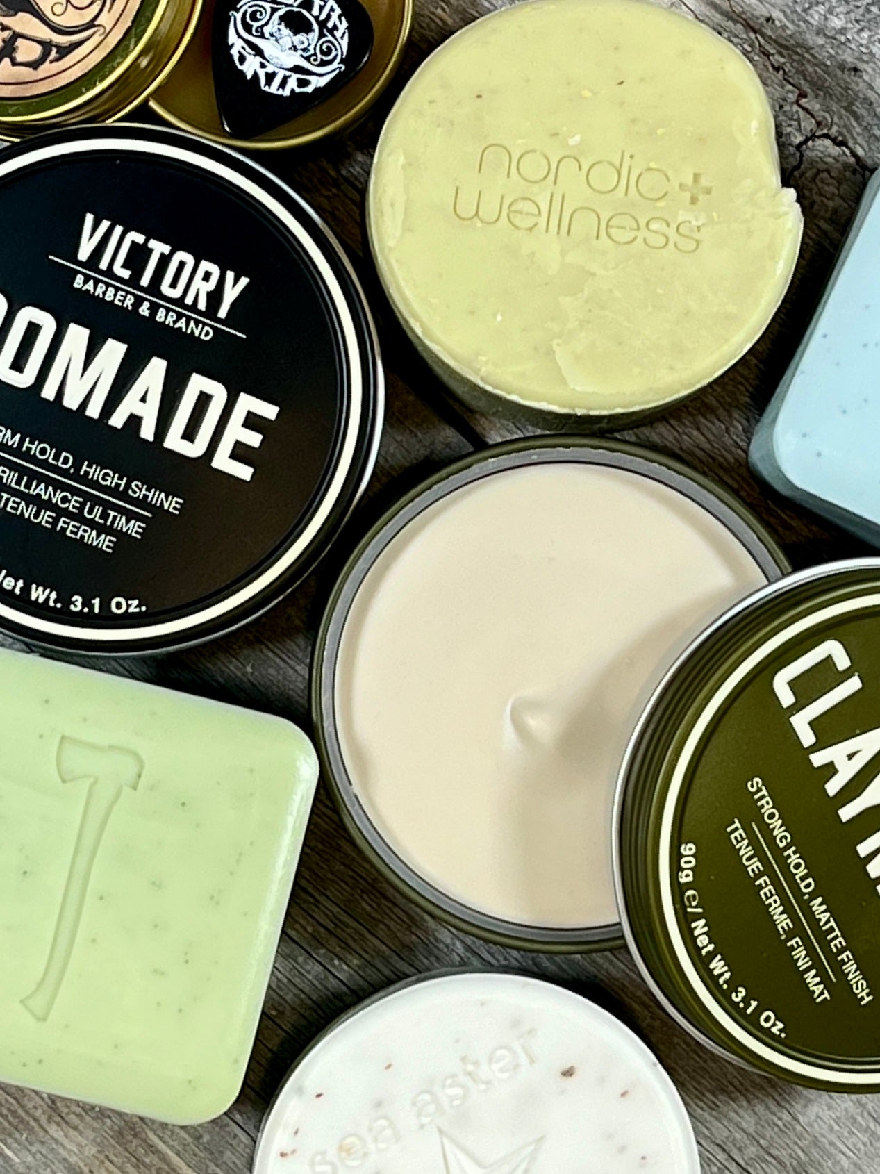 Various soaps and hair care products set on a wood surface.