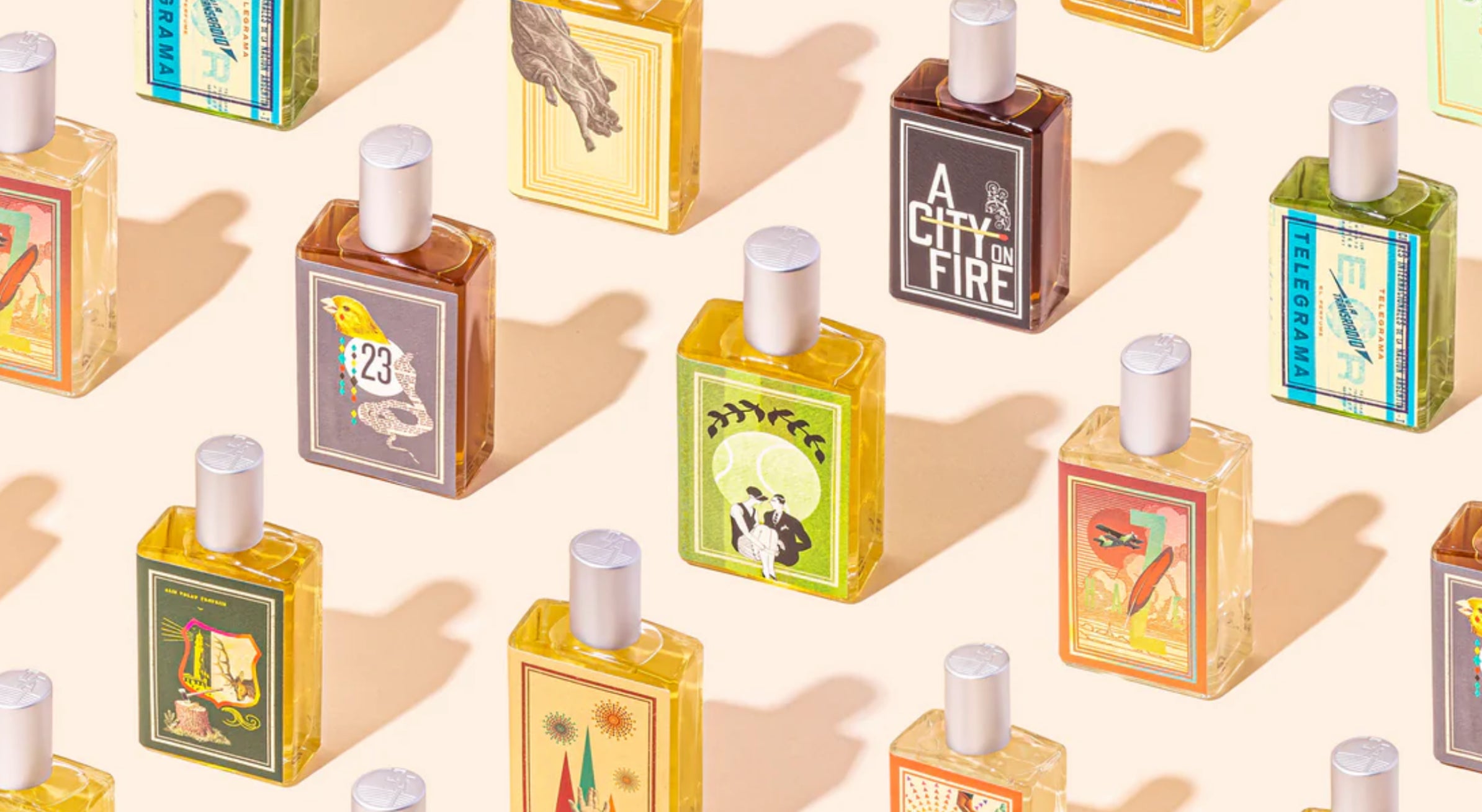 Pattern of small perfume bottles with colorful labels on a beige background